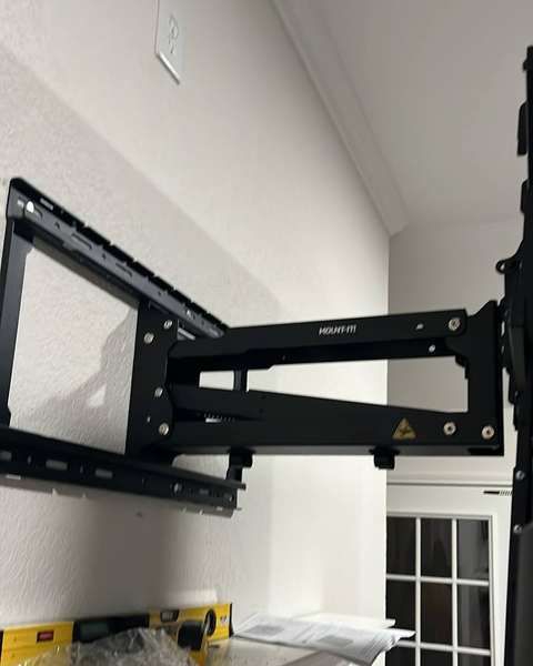 Full-motion TV arm bolted into wall studs
