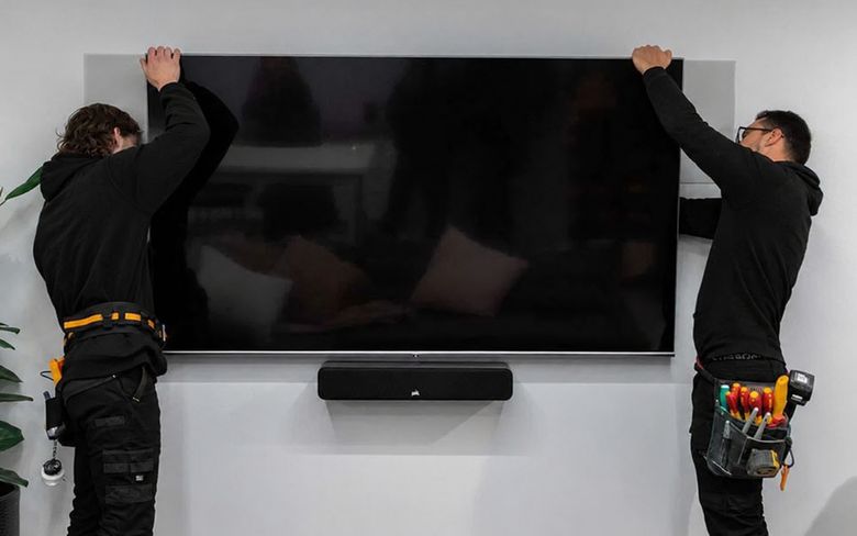 65-inch TV mounted above an electric fireplace on a slatted wall